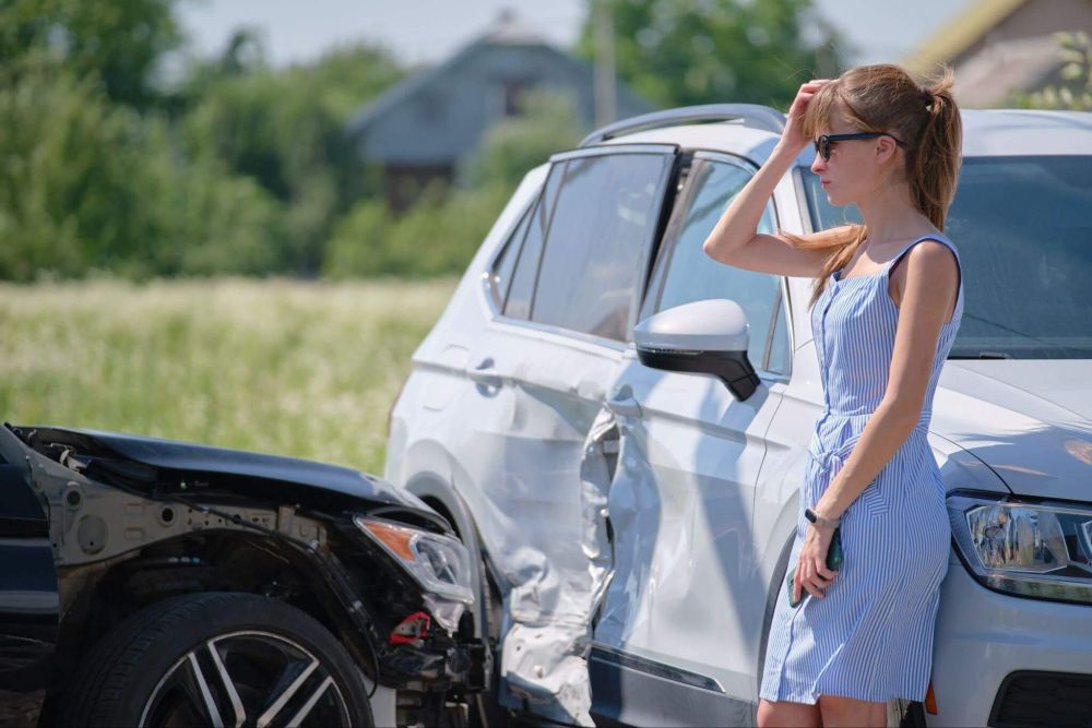 a woman standing next to a white car