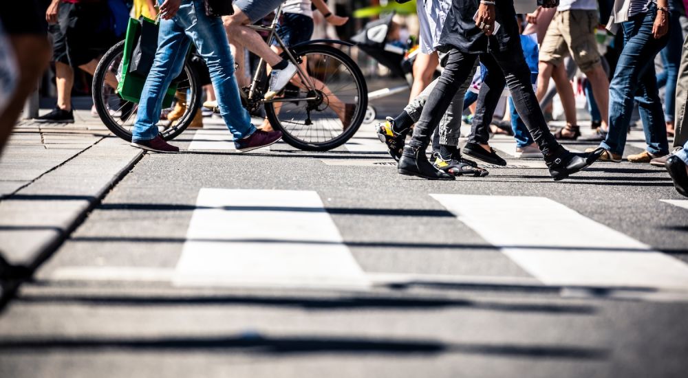 Many people walking on a crosswalk