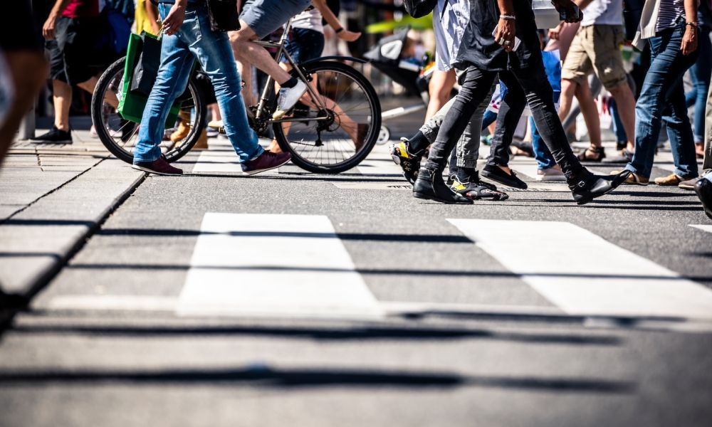 Many people walking on a crosswalk