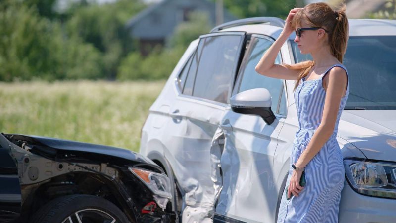 a woman standing next to a white car