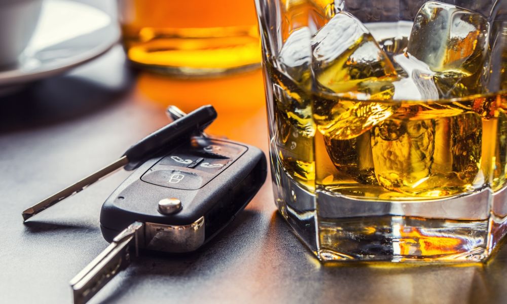 Car keys and glass of alcohol on table