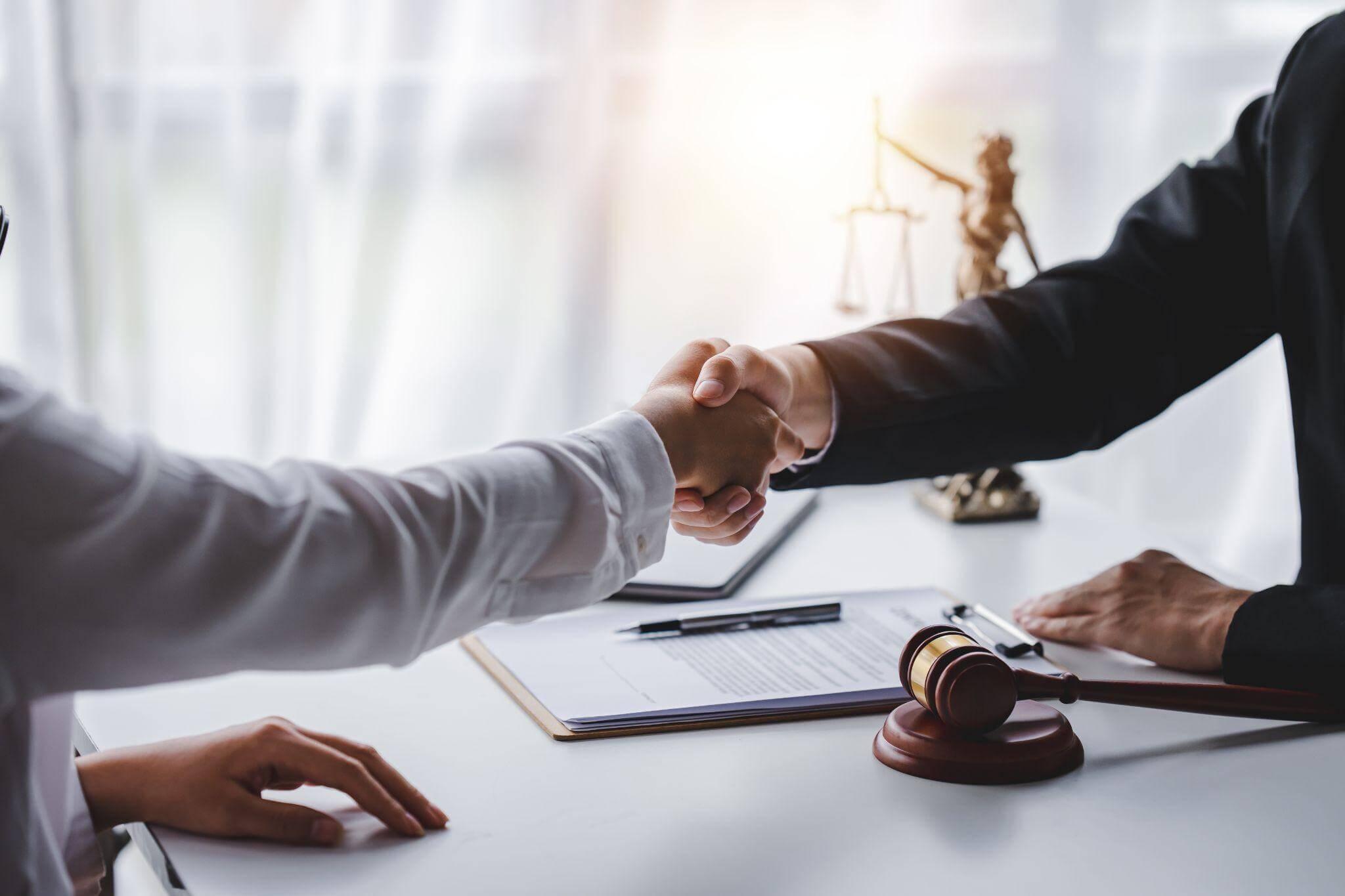 two people shaking hands in front of a judge