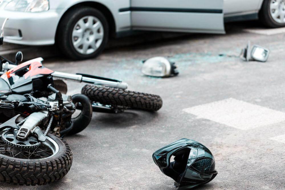 a motorcycle that is laying on the ground next to a helmet